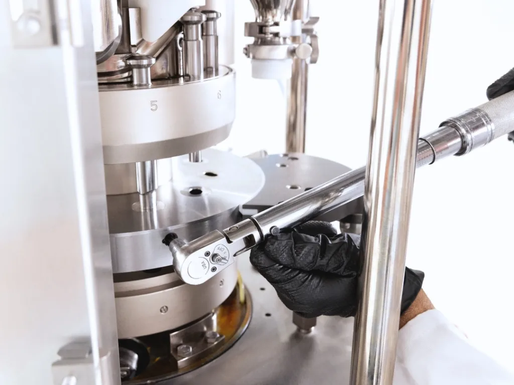 Service adjustments being made to a rotary tablet press.
